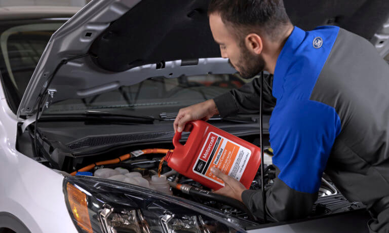 Ford technician pouring oil into car